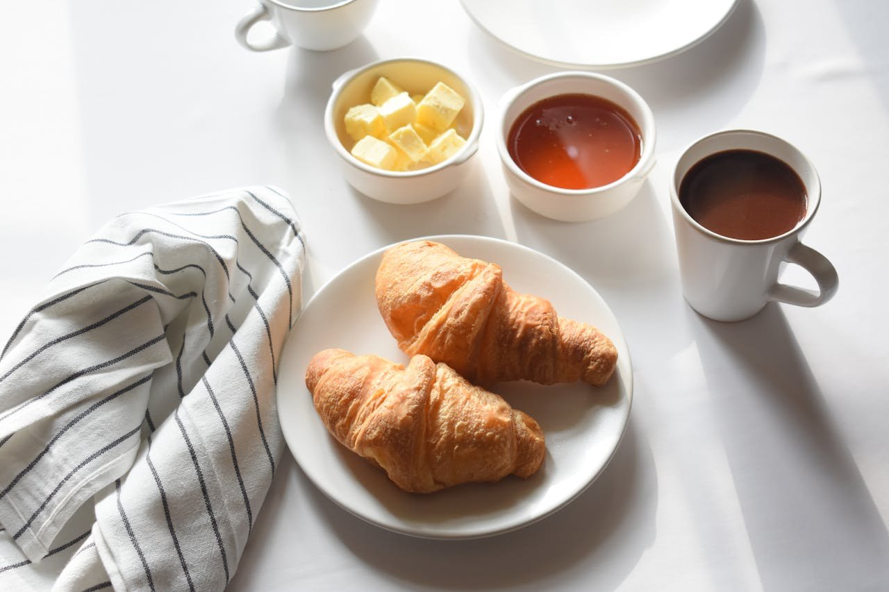 Savor a classic breakfast with buttery croissants and steaming coffee. Perfect start to your day.